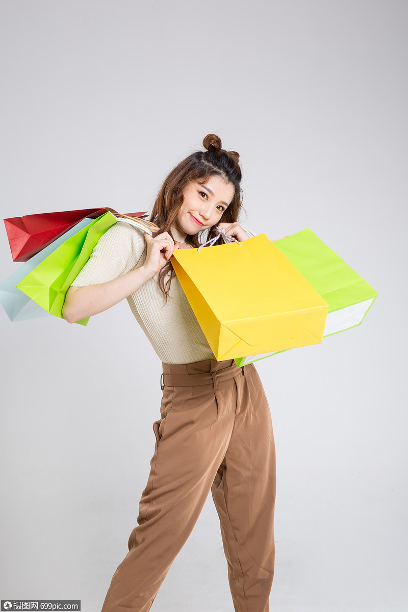 手拎购物袋的时尚女性棚拍