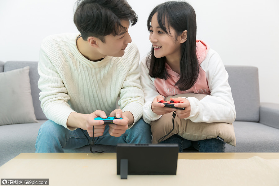 在客厅一起玩游戏的情侣