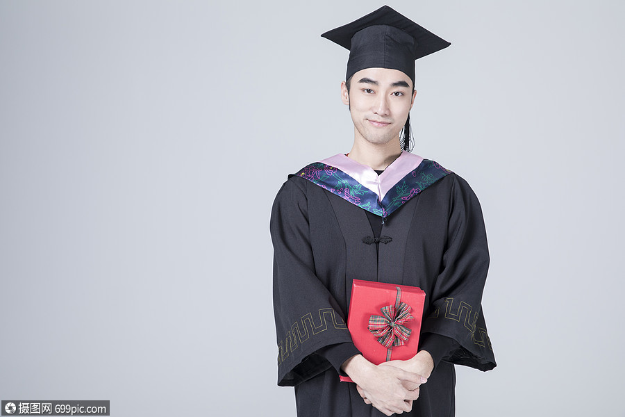 拿着礼物盒子的毕业男士学士服学士帽