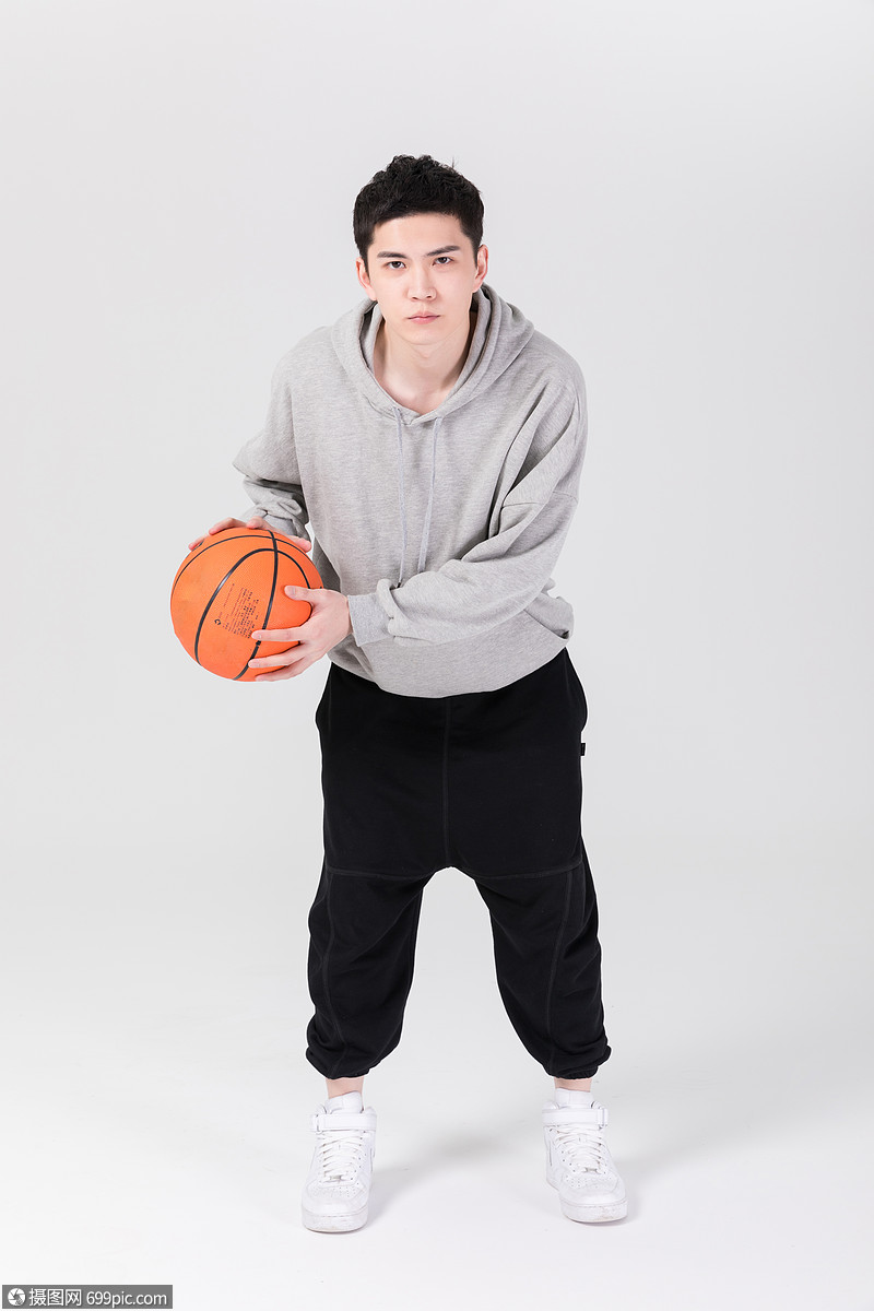拿着篮球打篮球的年轻男生