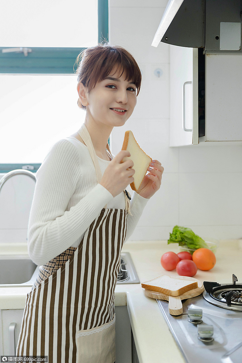 家庭主妇吃面包厨房灶台