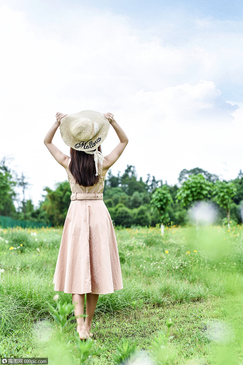 手拿草帽的女生背影