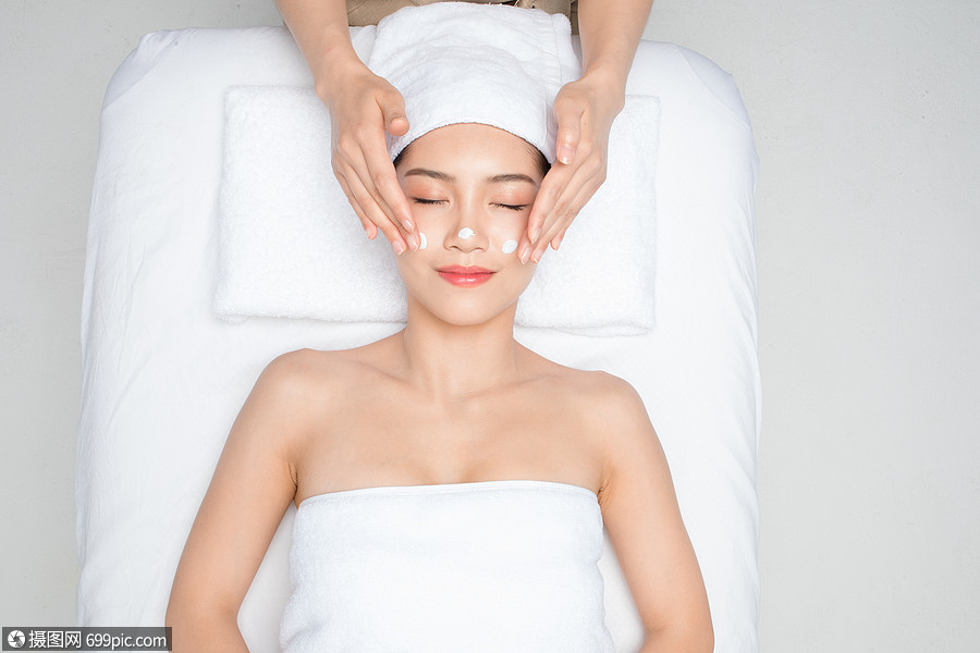 躺在床上做面部按摩的女性美容脸部