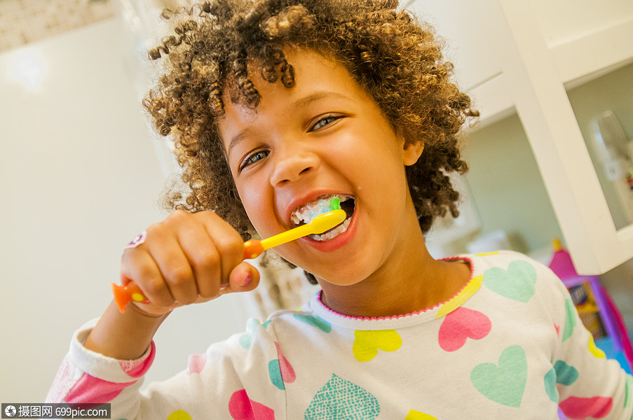 在浴室刷牙的微笑女孩的肖像早晨外国人