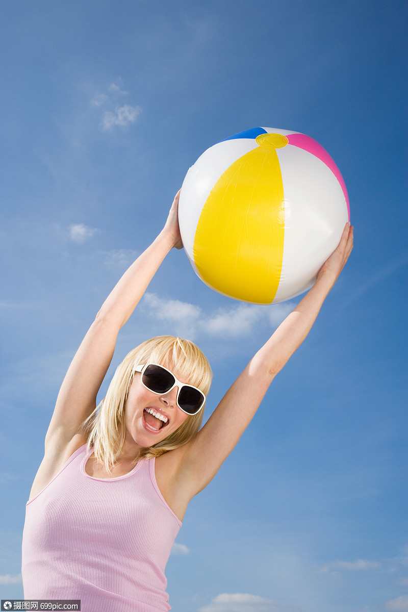带着沙滩球的年轻女子