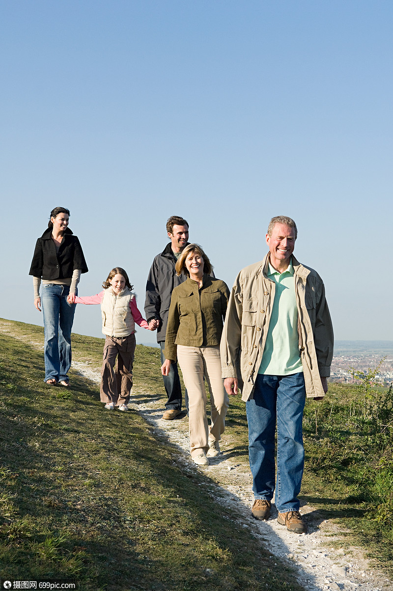 一家人在长满青草的山上散步