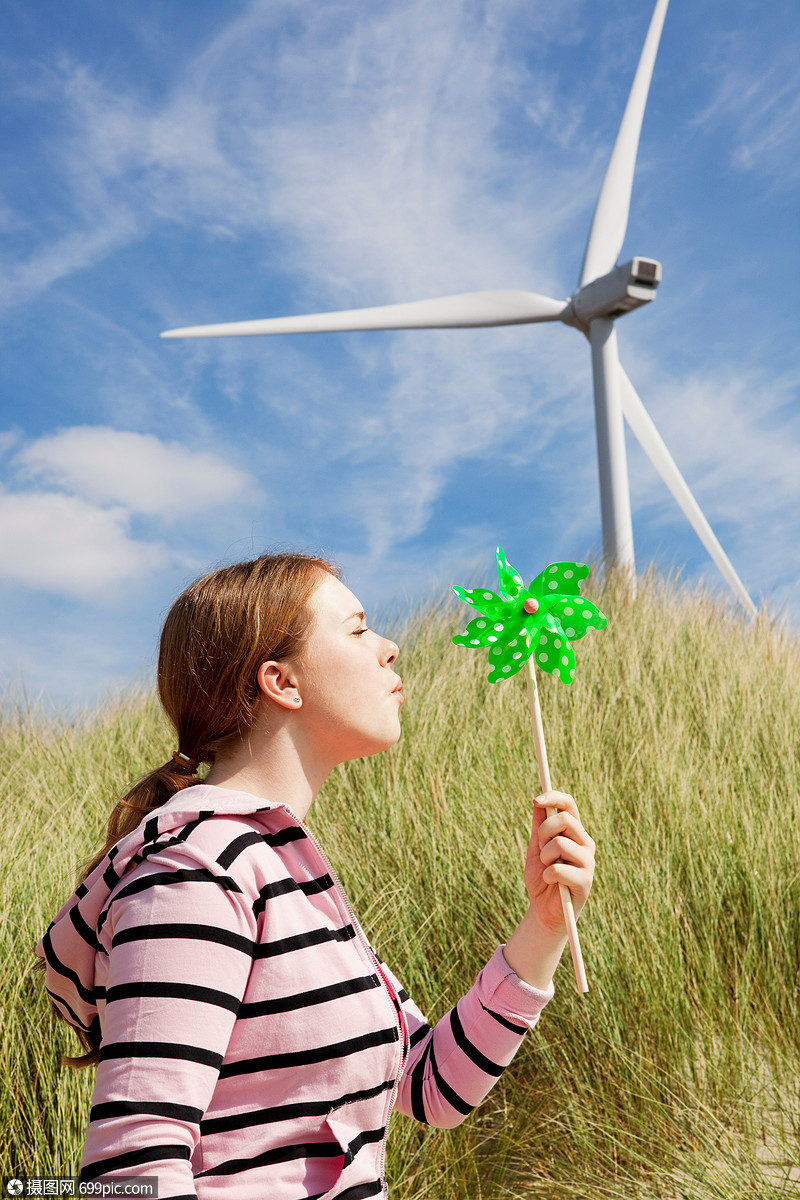 在草地上吹小风车的女孩