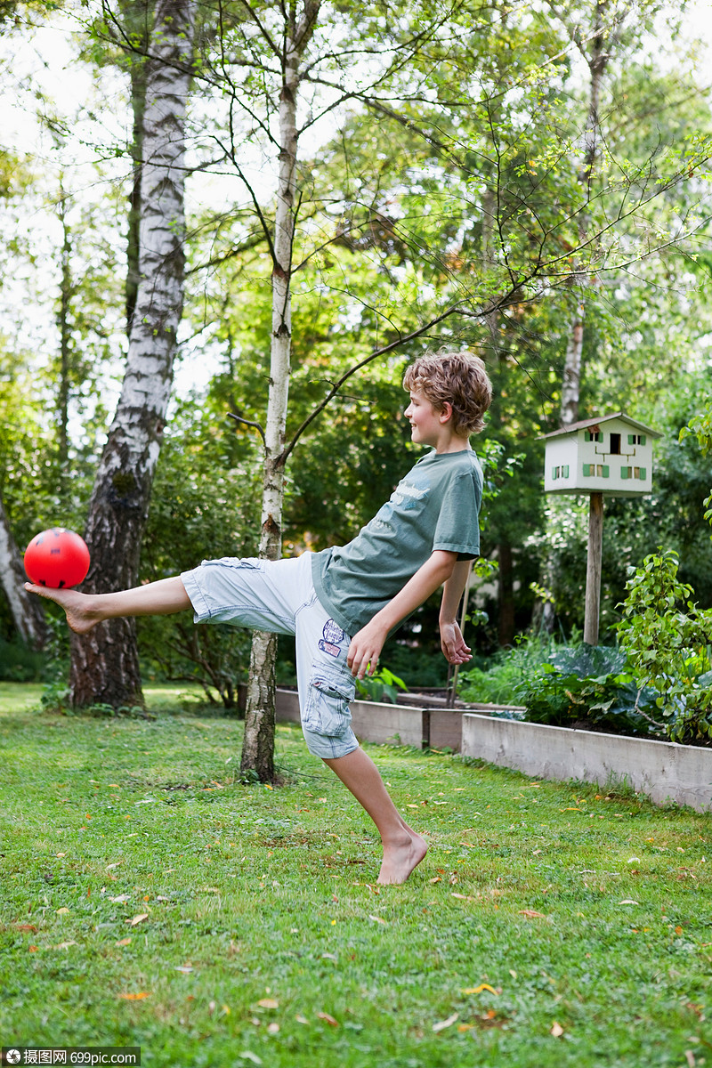 在花园里玩球的男孩光脚的童年
