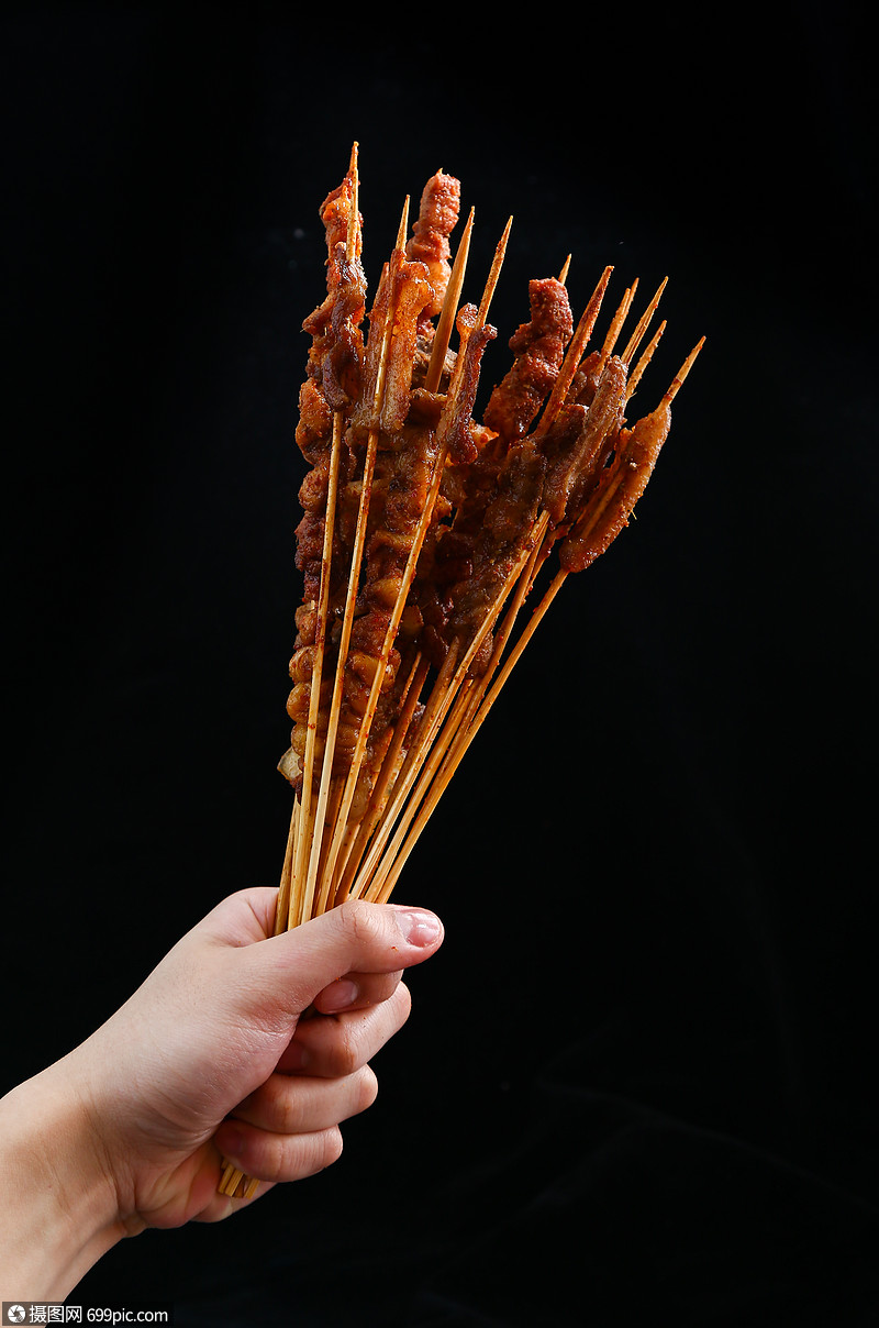 手拿诱人的夜宵烧烤肉串