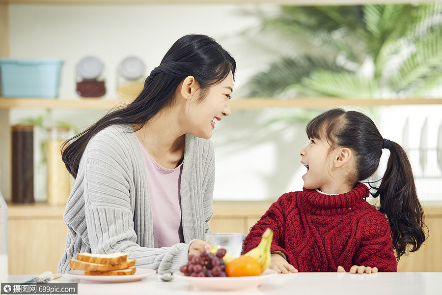 年轻妈妈和女儿吃早餐互动