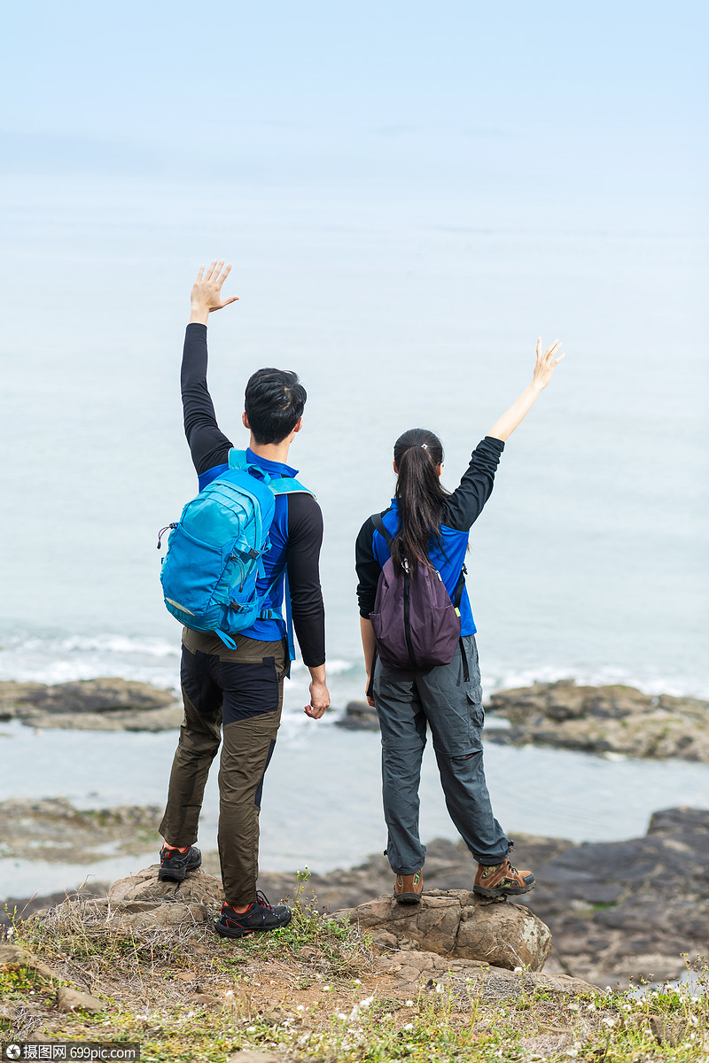 野外海边背包男女挥手
