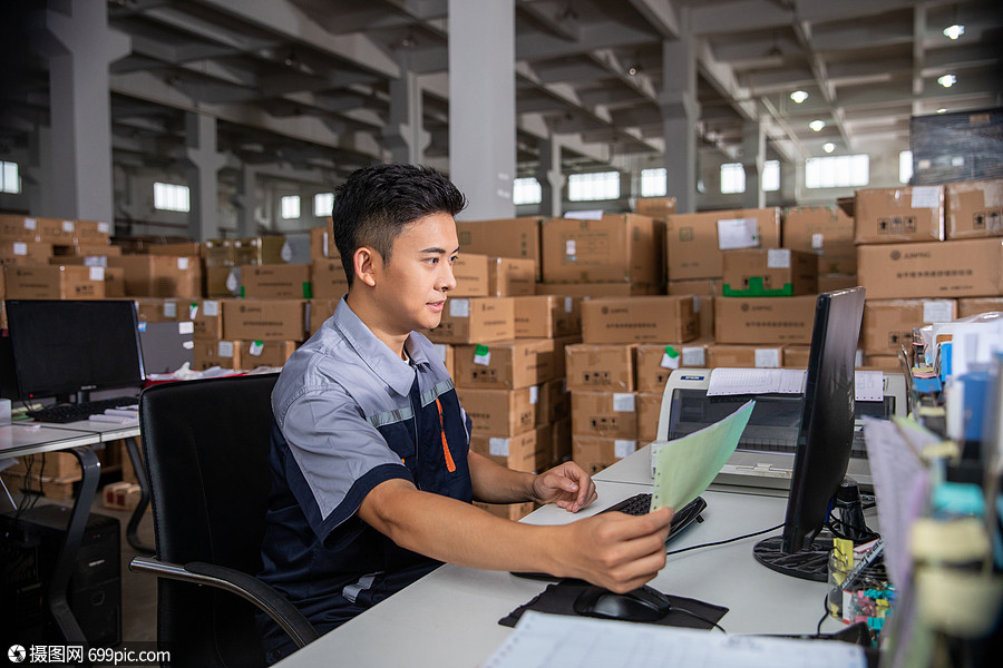 物流工人在电脑前打印物流单