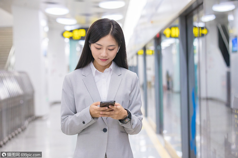 商务女性在地铁站玩手机