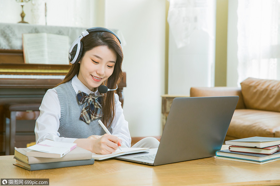 戴耳机的女学生上网课做笔记视频女生