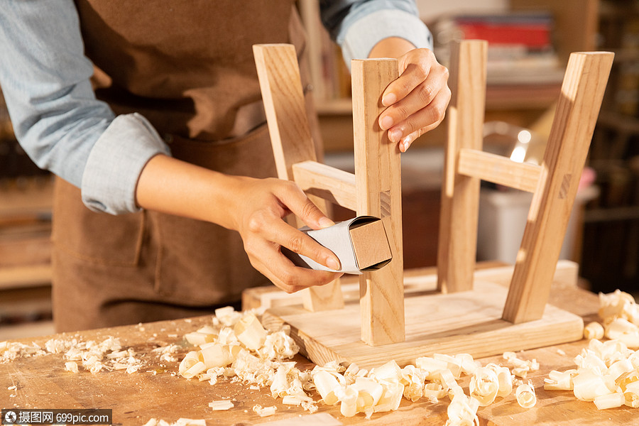 木匠工人打磨木头凳子手艺工作室