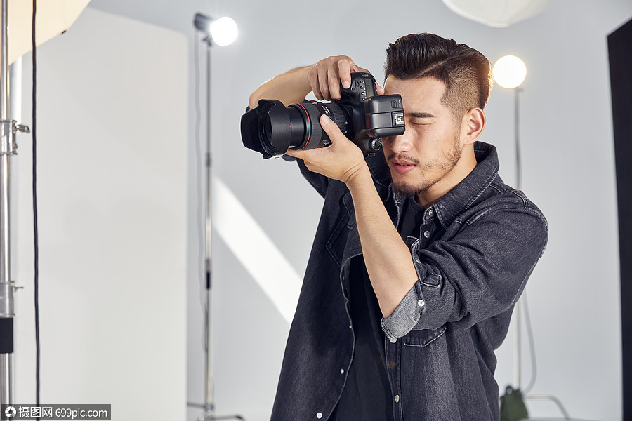 摄影师手拿相机拍摄形象工作室影棚