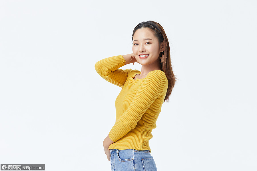 穿黄色毛衣单手撩头发的长发美女