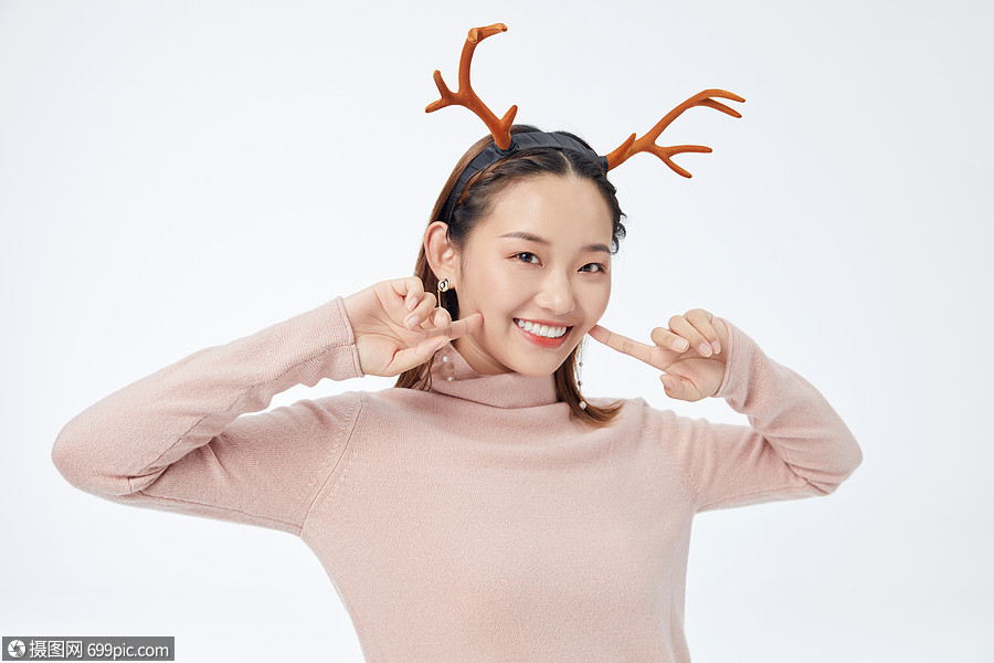 戴着鹿角双手指脸颊自信微笑的长发美女开心亚洲人