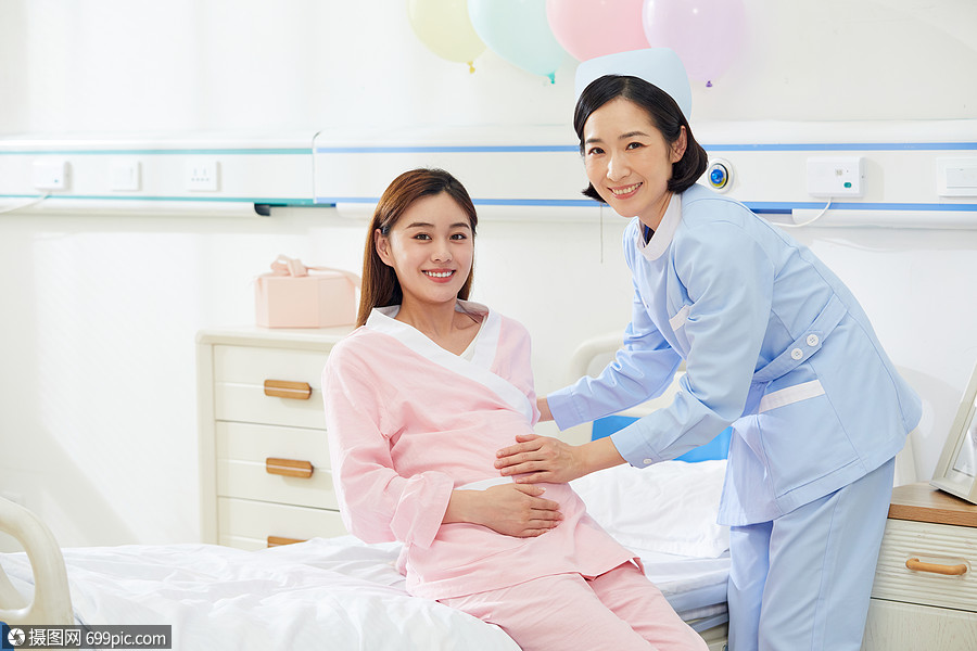 医院产房护士扶着孕妇上病床