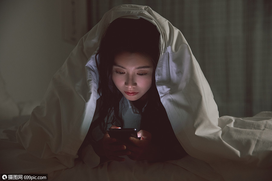 青年女性被窝里自熬夜玩手机游戏