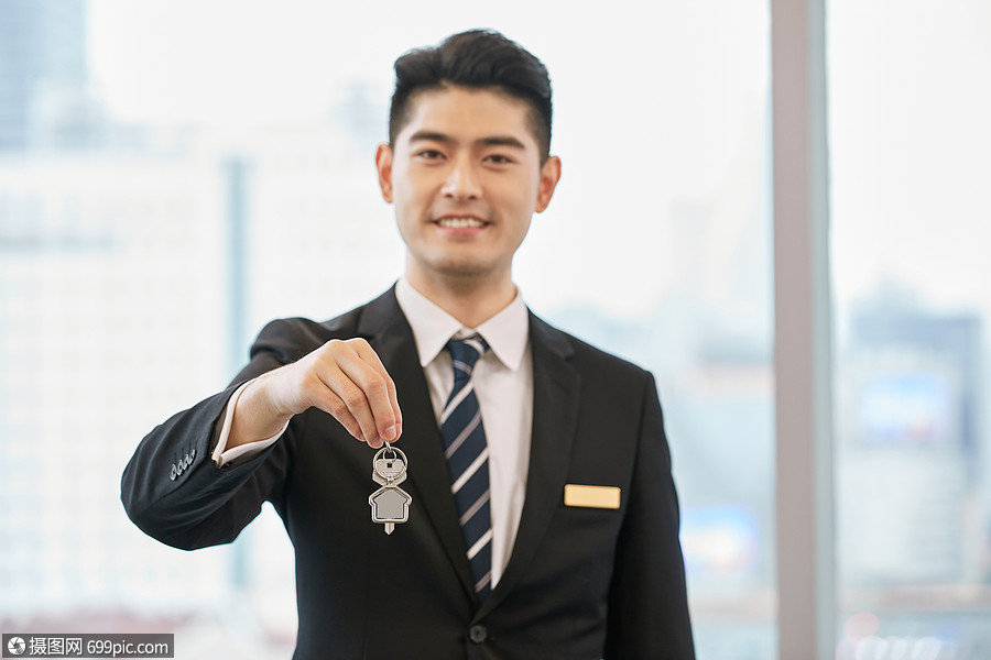 手拿钥匙交房的房产销售
