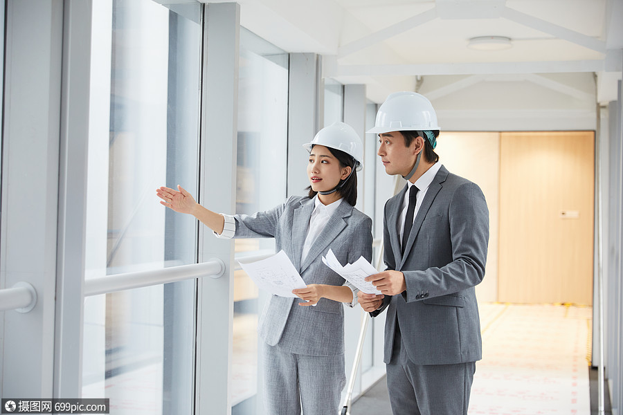 建筑工程师拿设计图纸讨论施工项目设计师男性