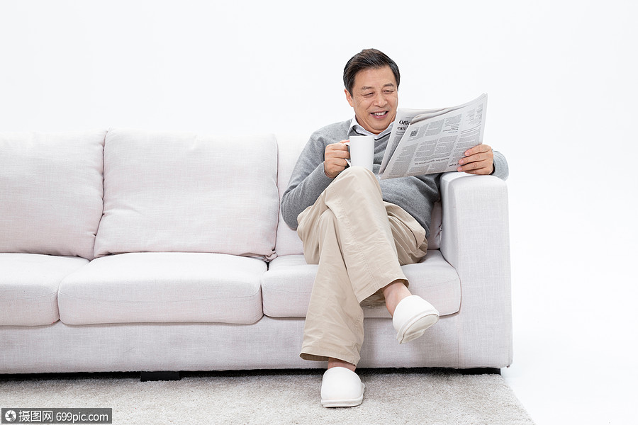 老人坐在沙发上享受咖啡看报纸