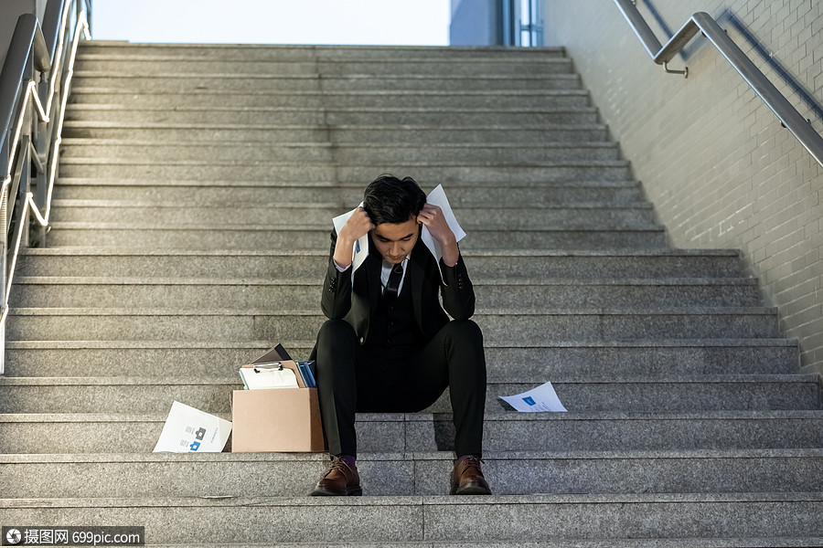 被辞退的商务男性失落的坐在楼梯上