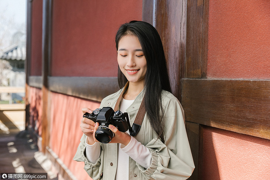 美女大学生一个人旅行拍照看相机
